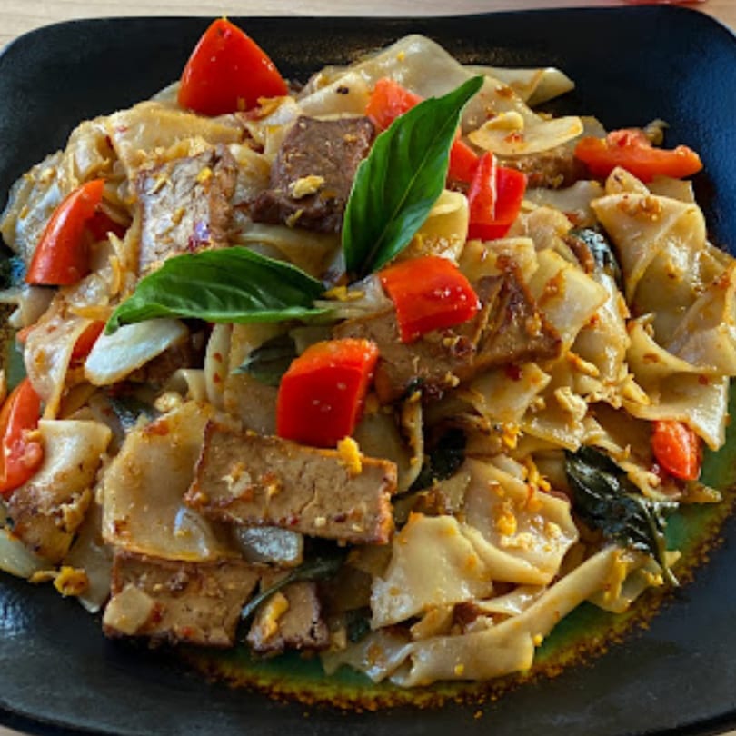 Penny's Thai Drunken Noodles with wide rice noodles, beef, tomatoes, and basil.